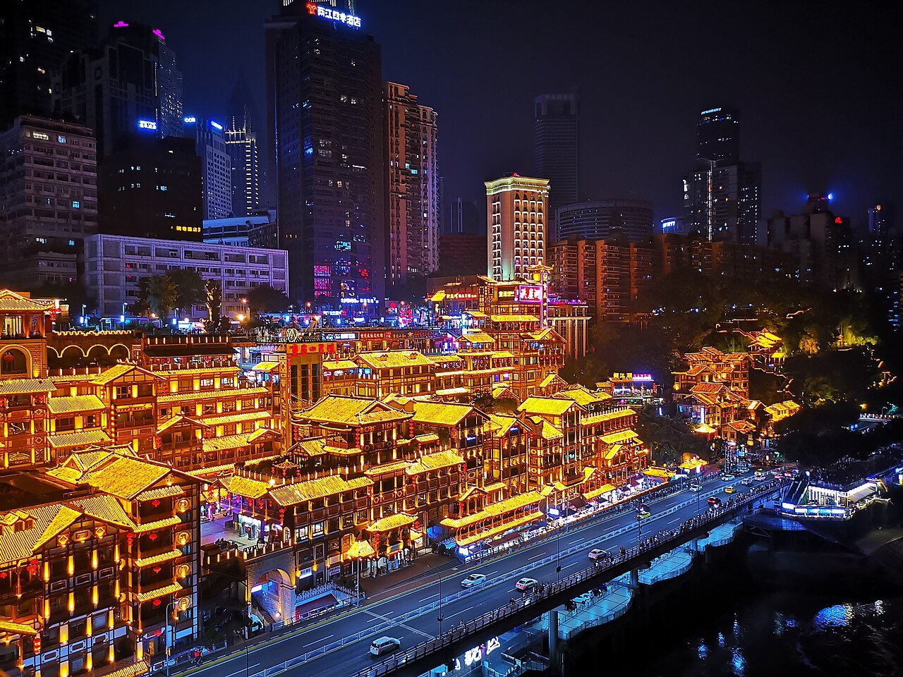 Chongqing Hongyadong — GeoffLeng, CC BY-SA 4.0. Source: https://commons.wikimedia.org/wiki/File:重庆洪崖洞.jpg; license: https://creativecommons.org/licenses/by-sa/4.0/. Responsive crop. Chongqing, China